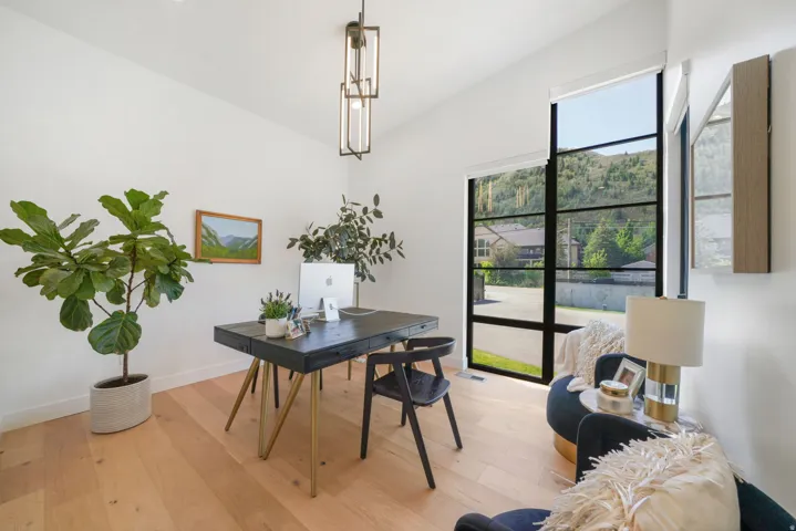 Bright interior space featuring light wood-finish flooring, white walls, and a vaulted ceiling