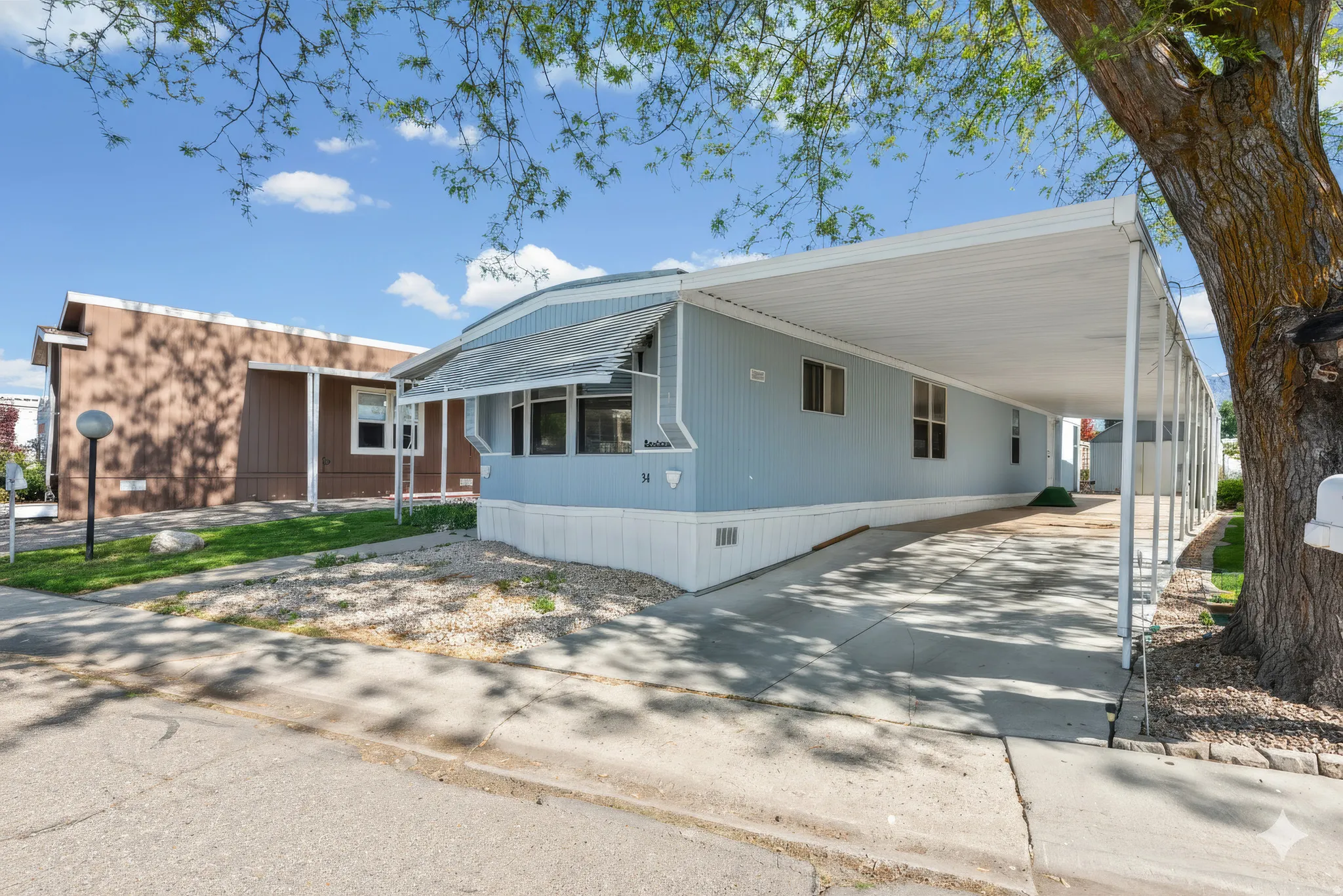 Light blue siding exterior with white trim and a covered carport