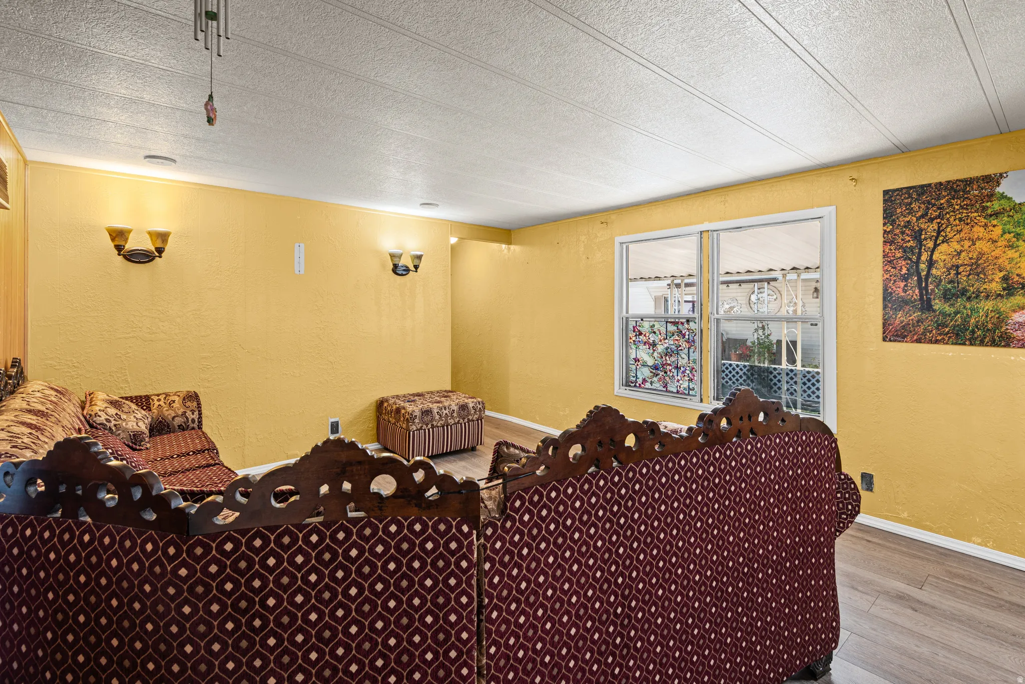 Interior space featuring light wood-finish flooring, textured wall finishes, and a drop ceiling