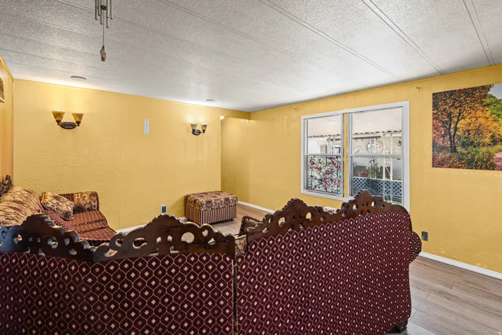 Interior space featuring light wood-finish flooring, textured wall finishes, and a drop ceiling