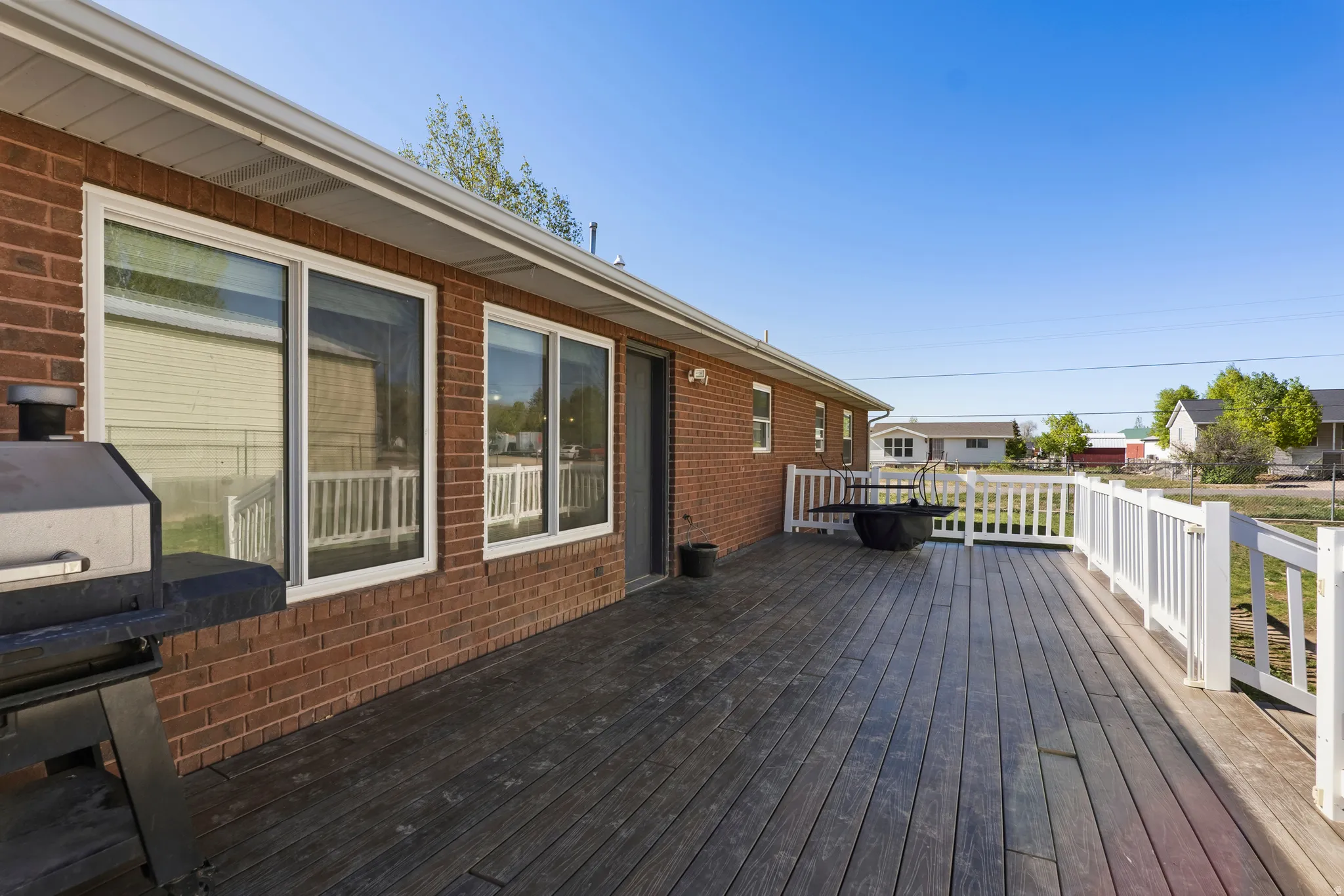 Expansive exterior deck featuring wood-finish planks and white railing