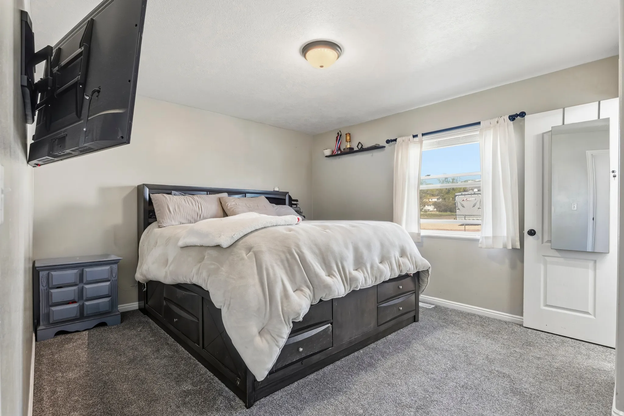 Carpeted room with a ceiling-mounted light fixture