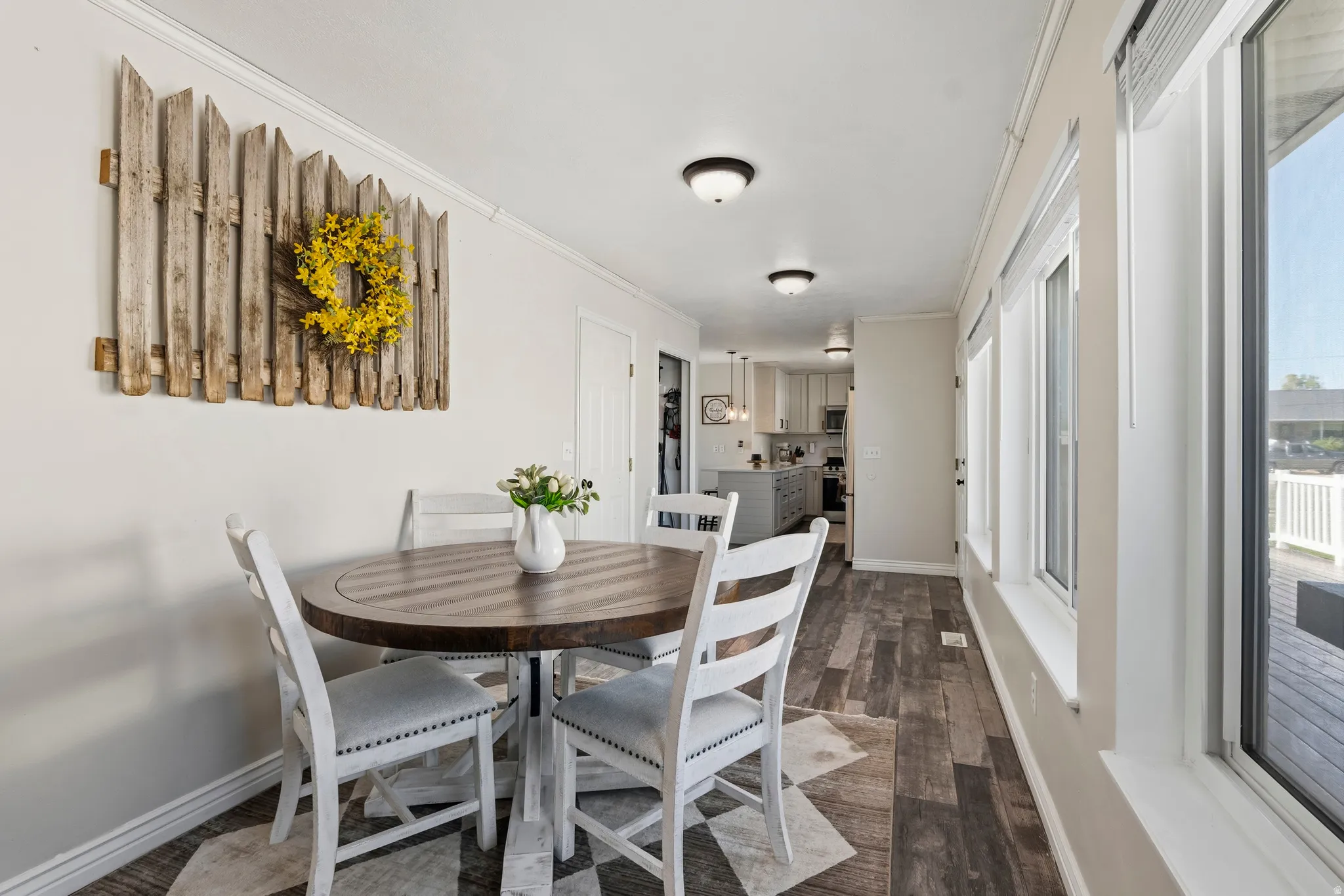 Dining area featuring wood-finish flooring, multiple windows, recessed lighting, and a sightline to the kitchen
