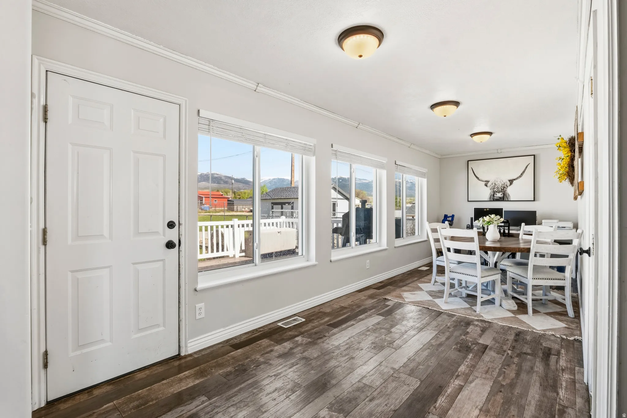 Light-filled room featuring wood-finish flooring and multiple windows