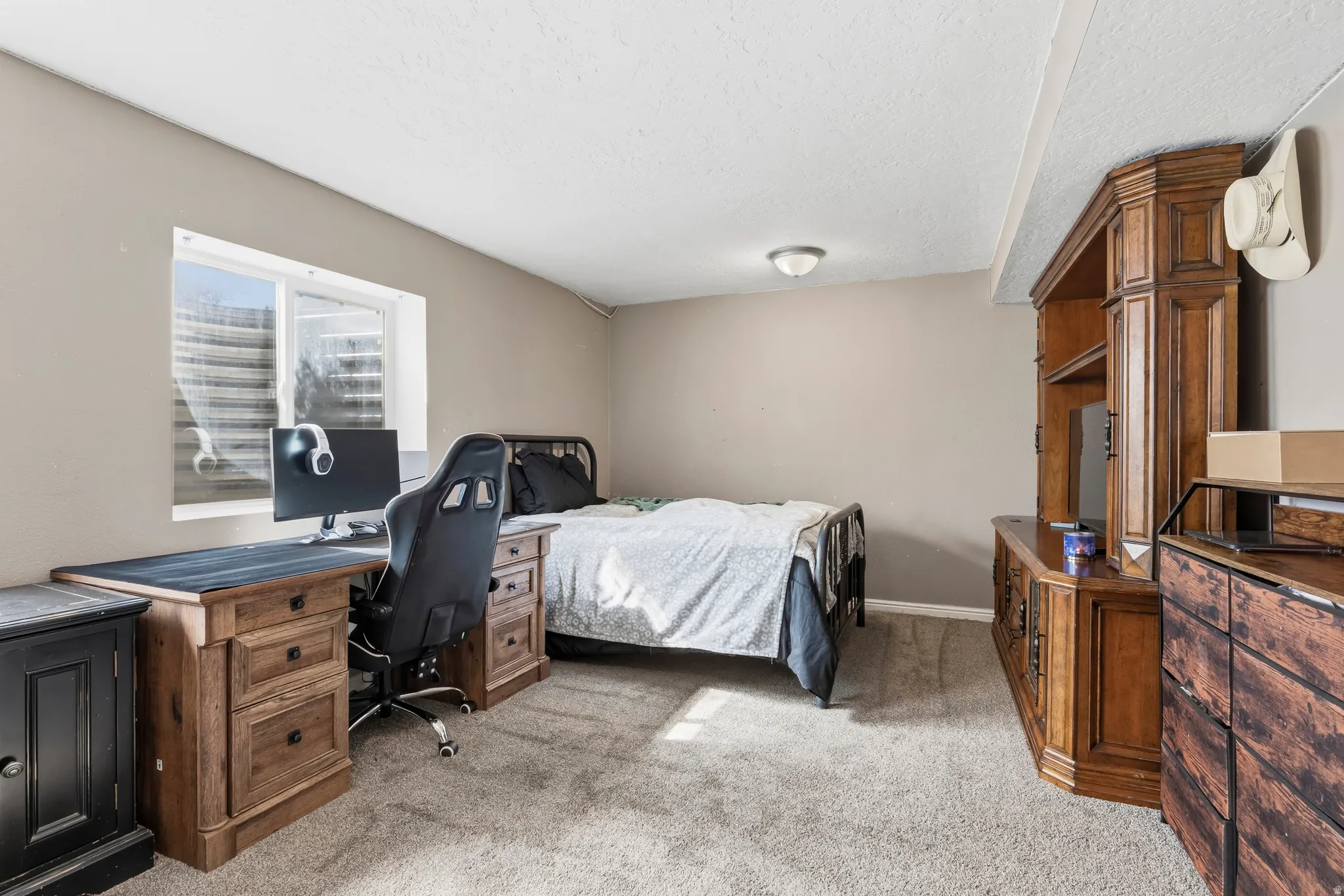 Carpeted room with a window, featuring a built-in media console and a recessed ceiling light