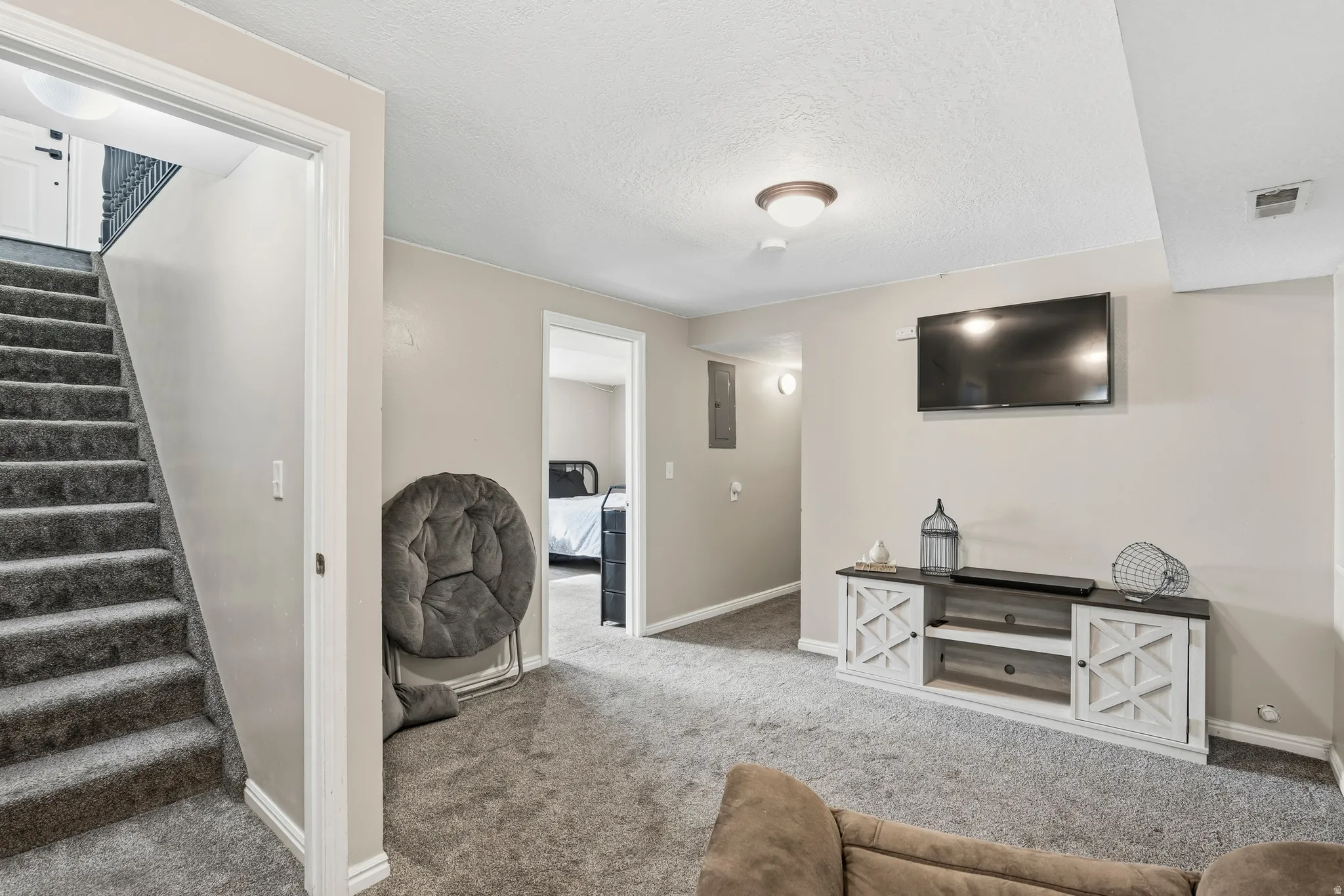 Carpeted lower level featuring a built-in media console with cabinet storage
