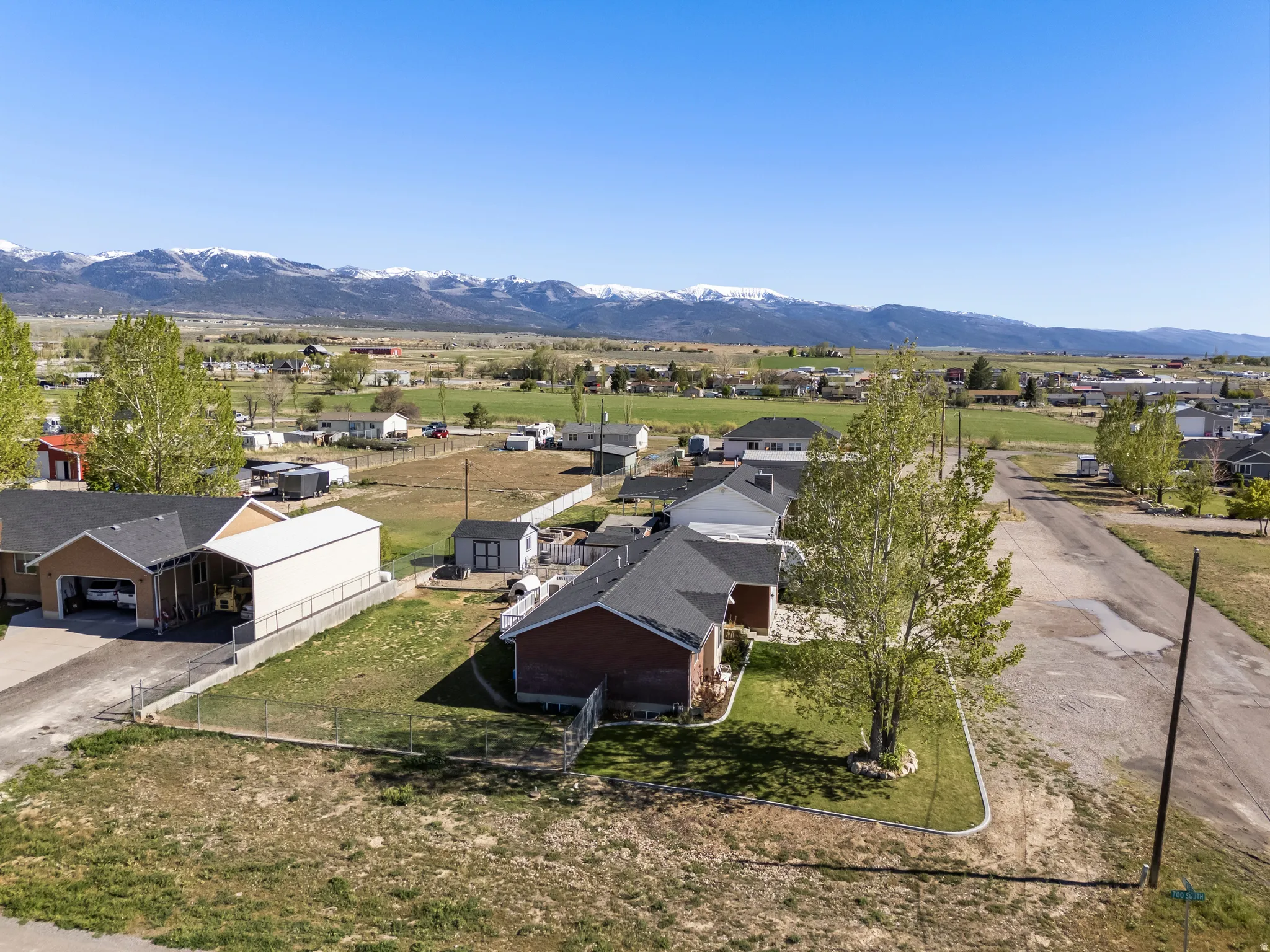 Expansive aerial perspective showcasing a residential property with a detached garage and an additional covered carport