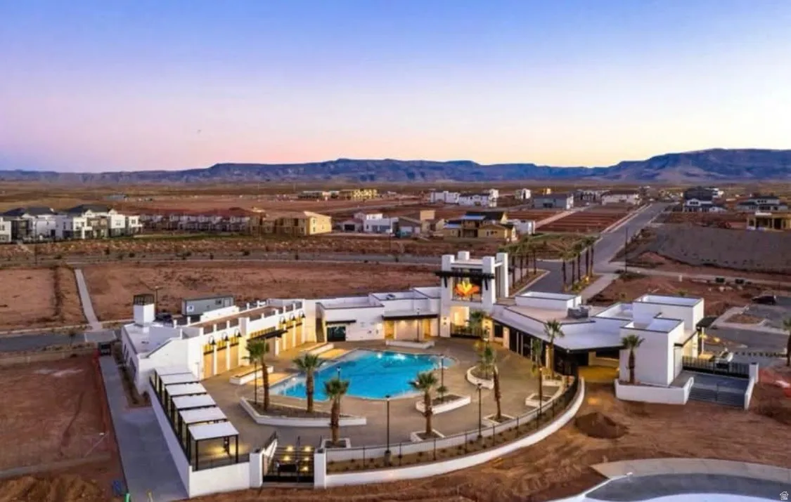 Resort-style pool area featuring a large swimming pool, surrounding patio space, and mature palm trees