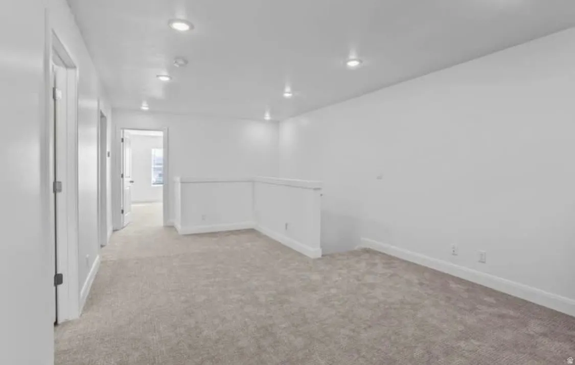 Spacious carpeted area featuring recessed lighting, white walls, and white trim