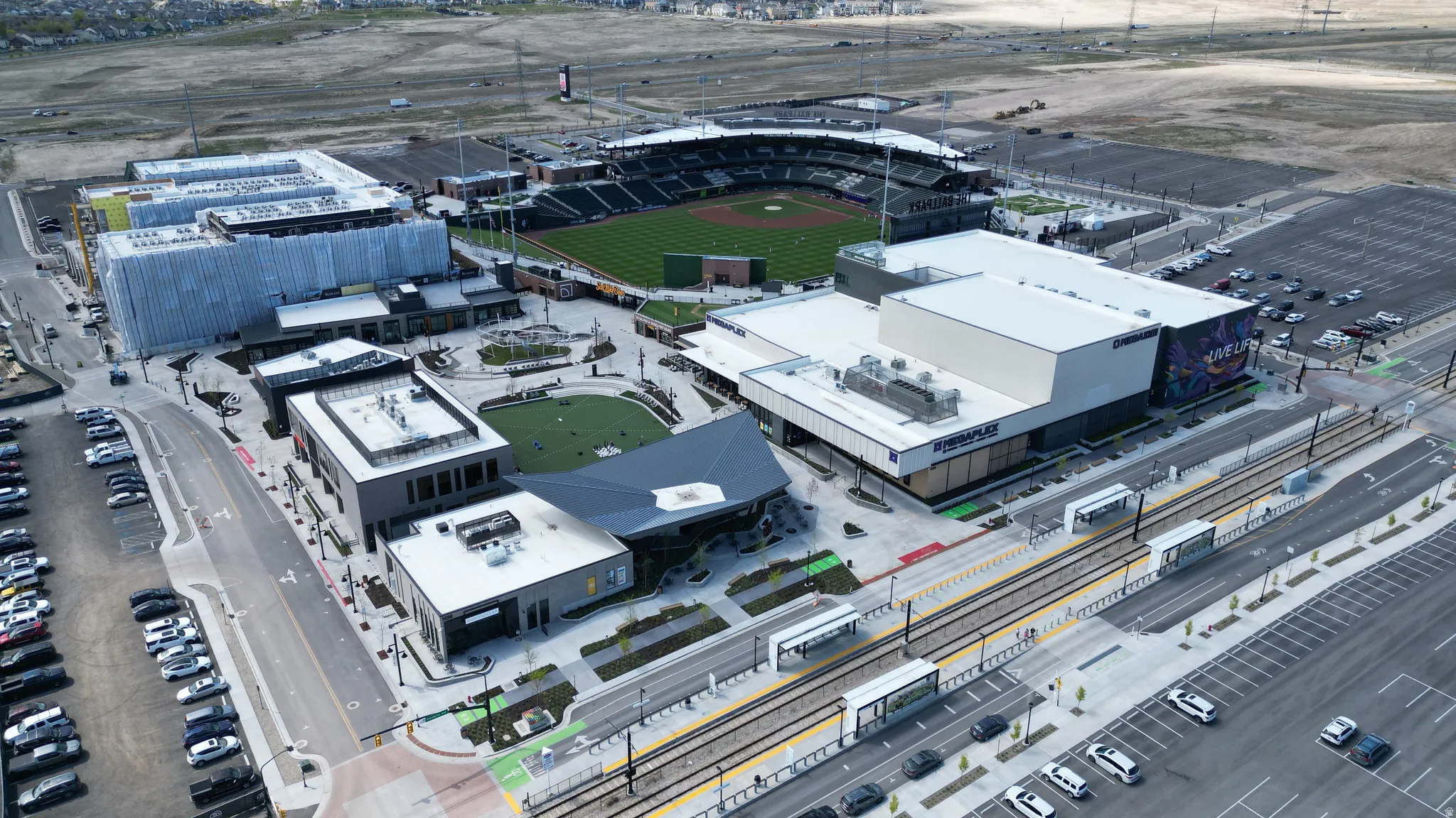 Urban development featuring a stadium, commercial buildings, and a transit line with multiple stops