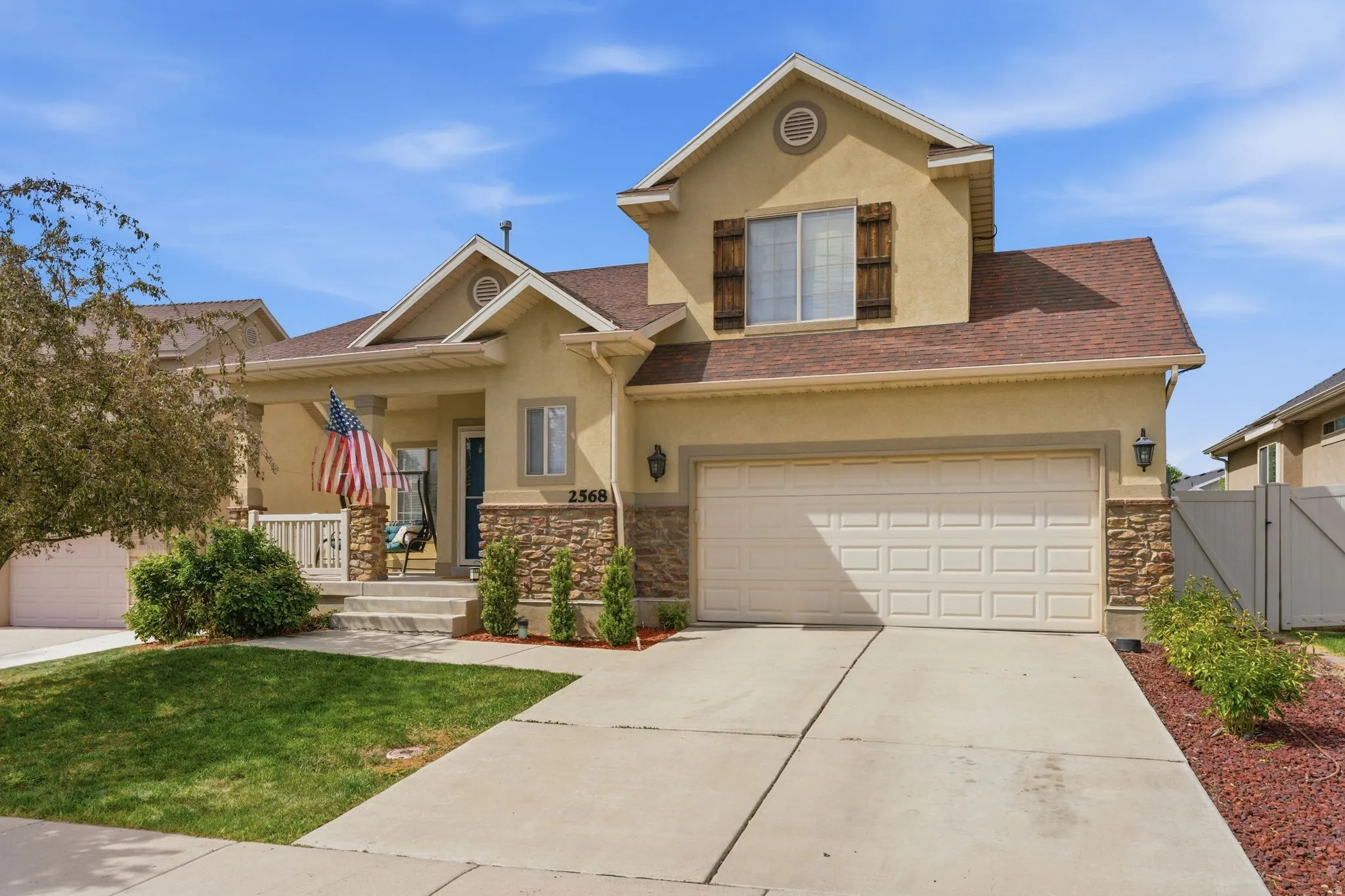 Two-story residence featuring a stucco and stone veneer exterior