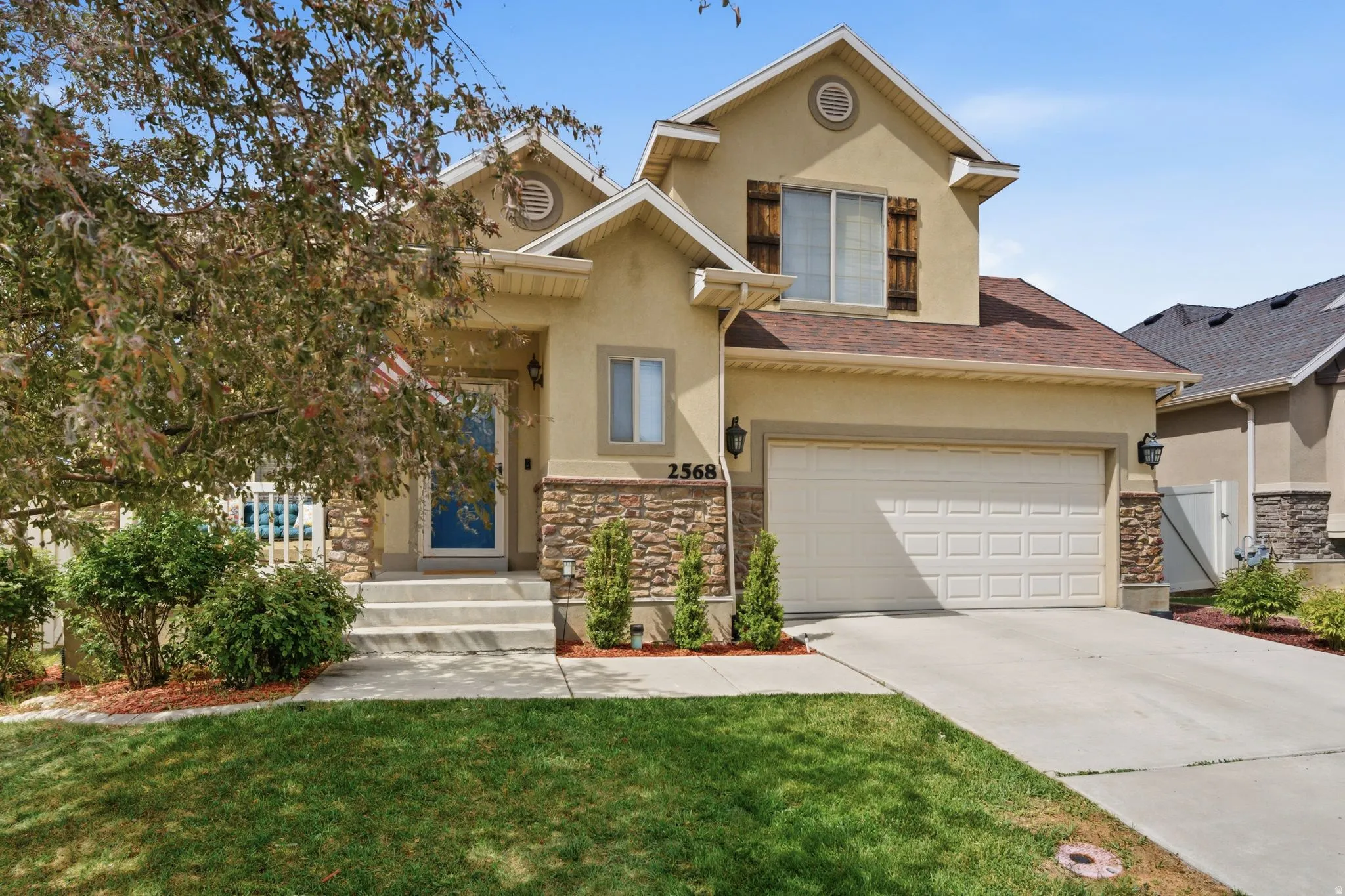 Stucco exterior with stone accenting and a two-car garage