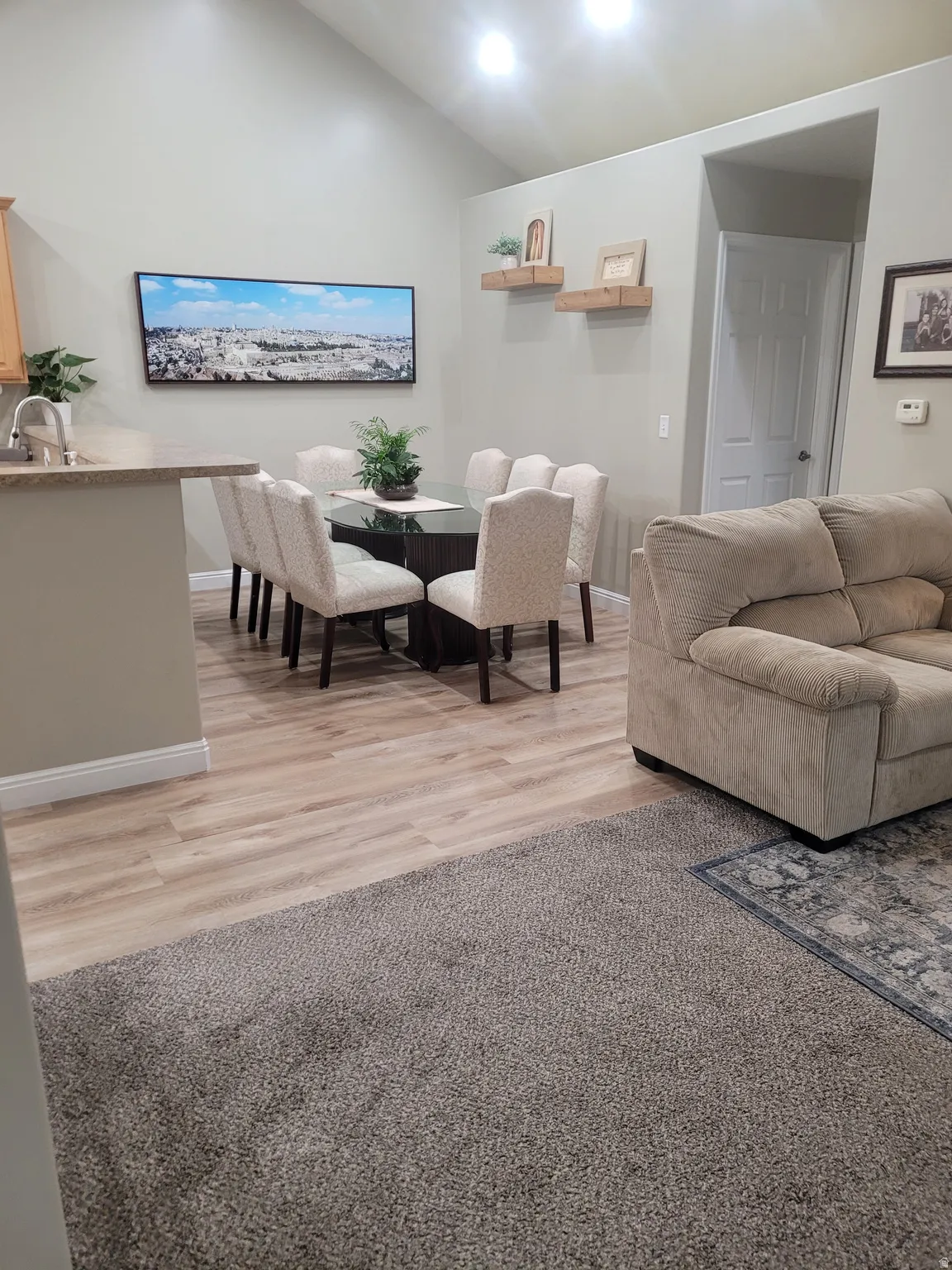 Open-concept living area featuring vaulted ceilings, recessed lighting, and wood-finish flooring