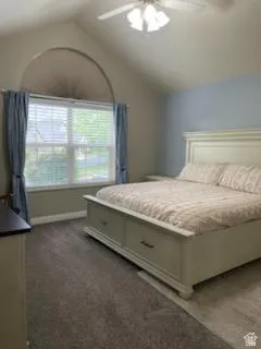 Vaulted ceiling bedroom with a large arched window