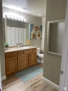 Bathroom featuring a single vanity with wood cabinetry, a light-toned countertop, and an integrated sink