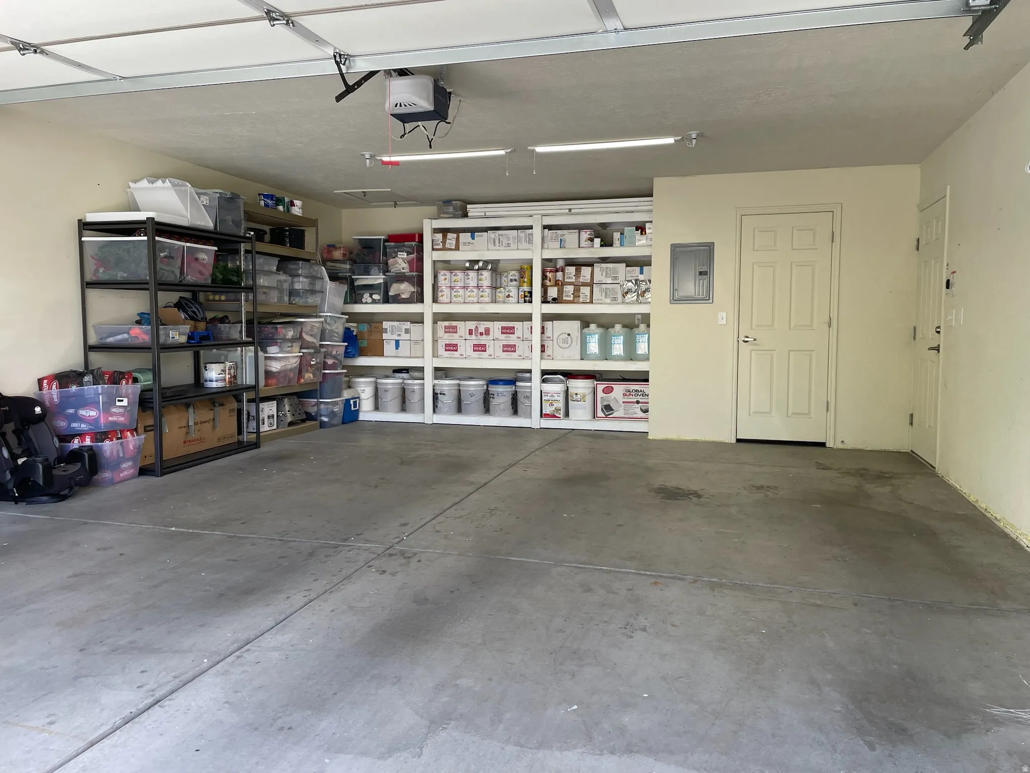 Garage space featuring a concrete floor, painted walls, and overhead lighting
