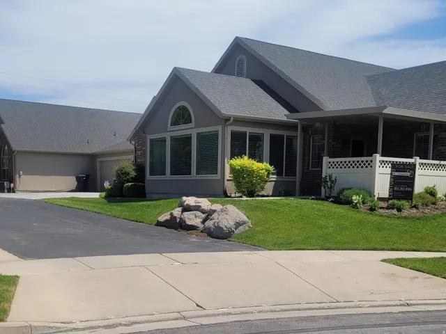 Exterior featuring a sunroom with an arched window, a covered porch, brick accents, and a multi-car driveway