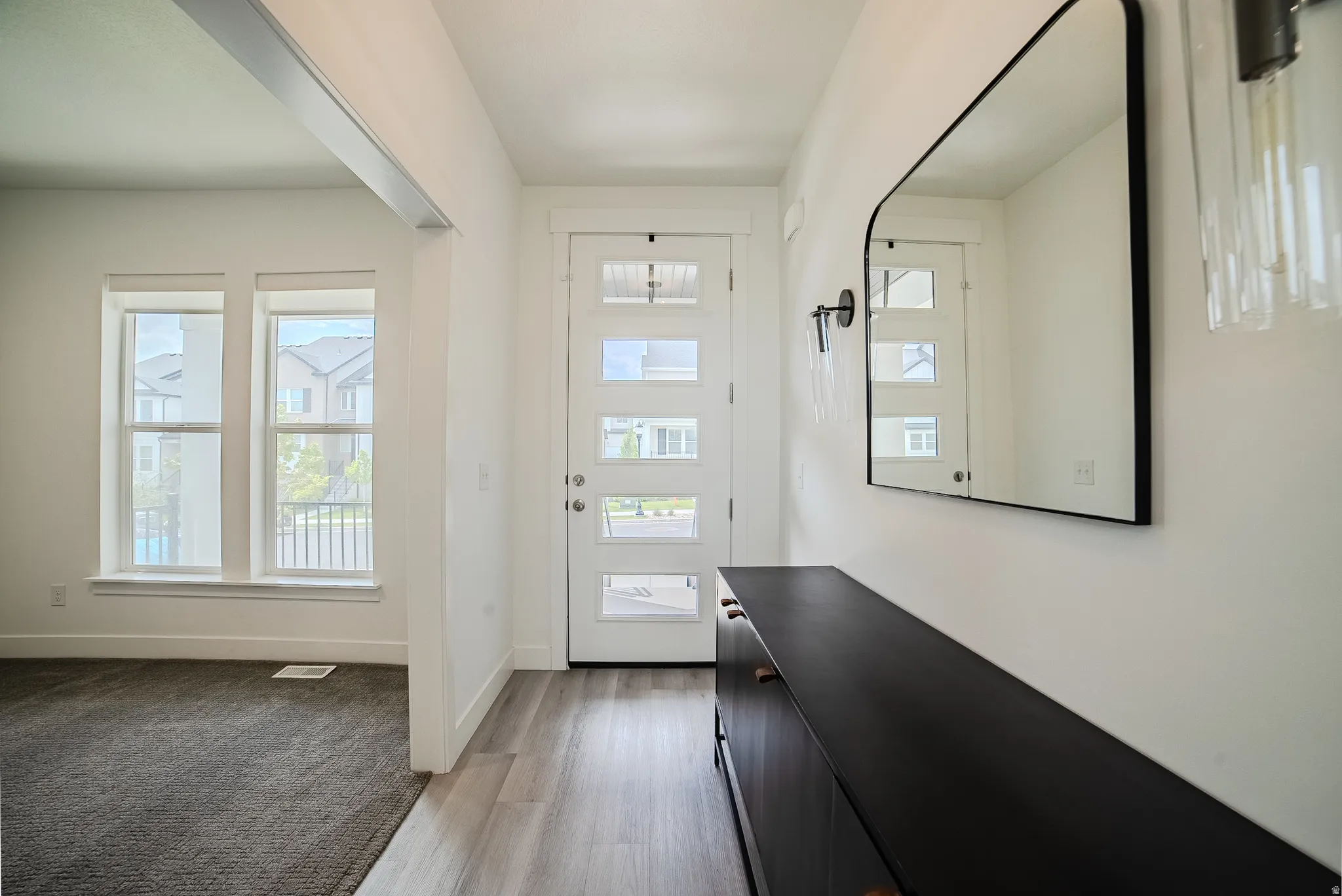 Entryway featuring wood-finish flooring, a contemporary front door with multiple glass lites, and a modern light fixture