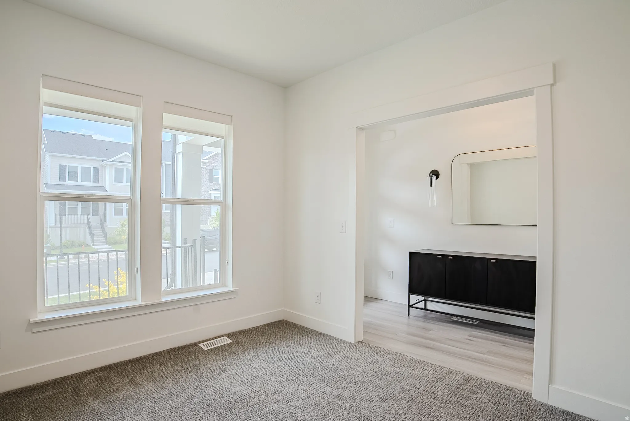 Bright interior featuring two large windows, white trim, and a wide entryway