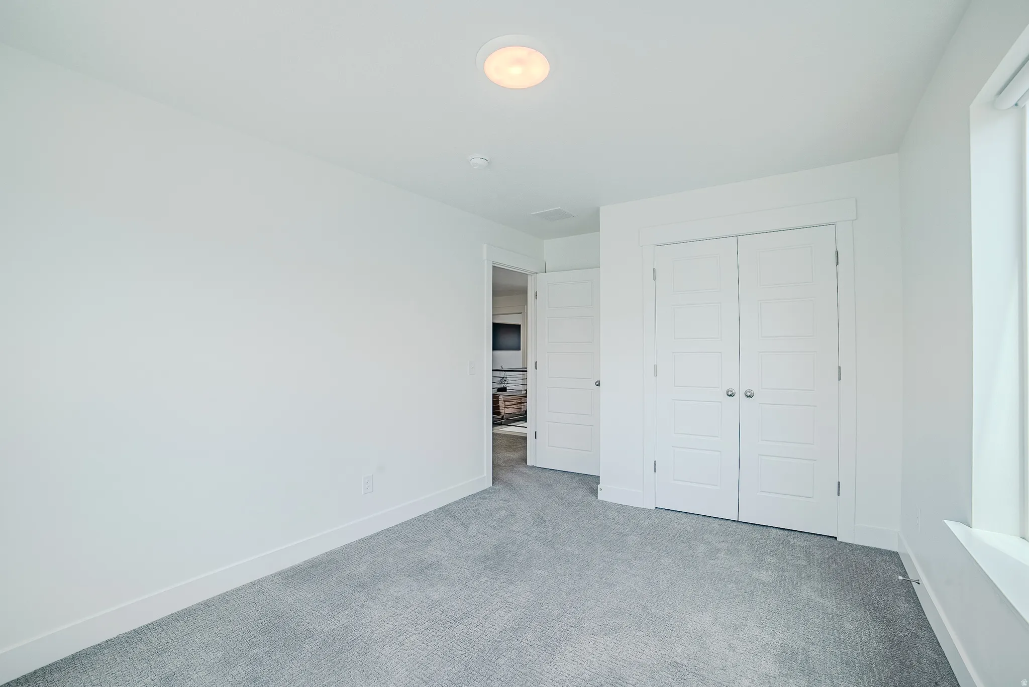 Bright room featuring light gray carpeting and white walls