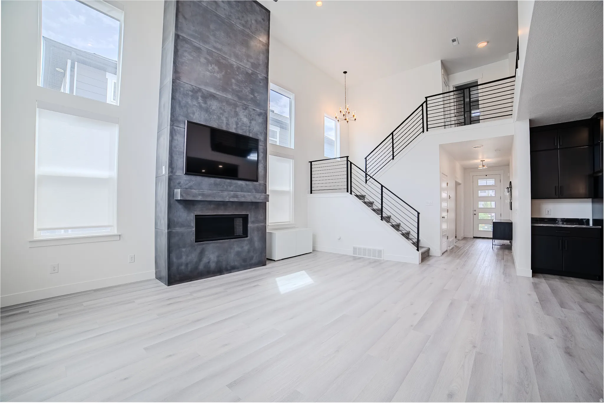 Two-story living area featuring a prominent dark-toned fireplace with an integrated media niche