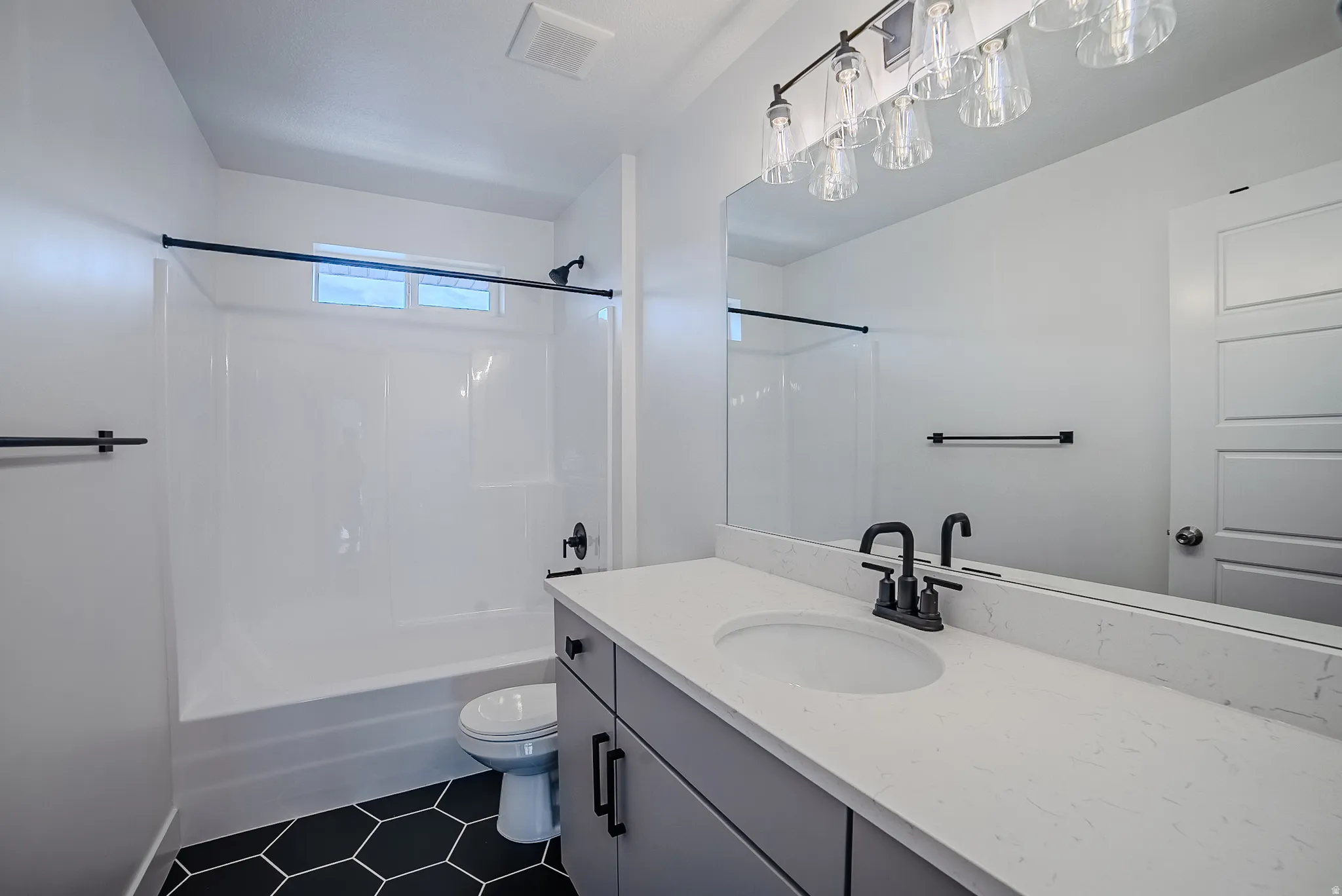 Modern bathroom featuring a white single vanity with a quartz-finish countertop and an undermount sink