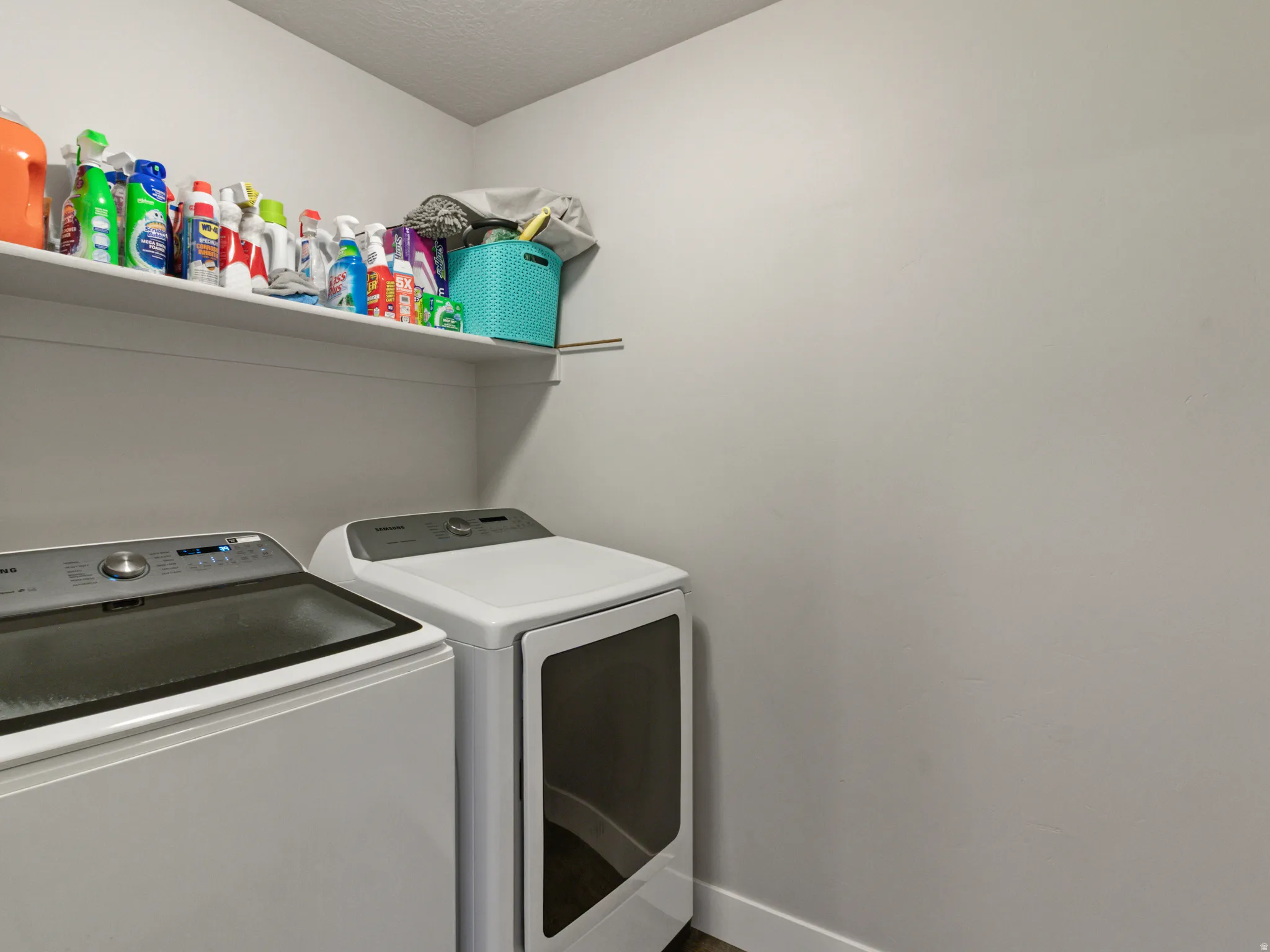 Dedicated laundry area featuring a built-in wall shelf and two appliance hookups