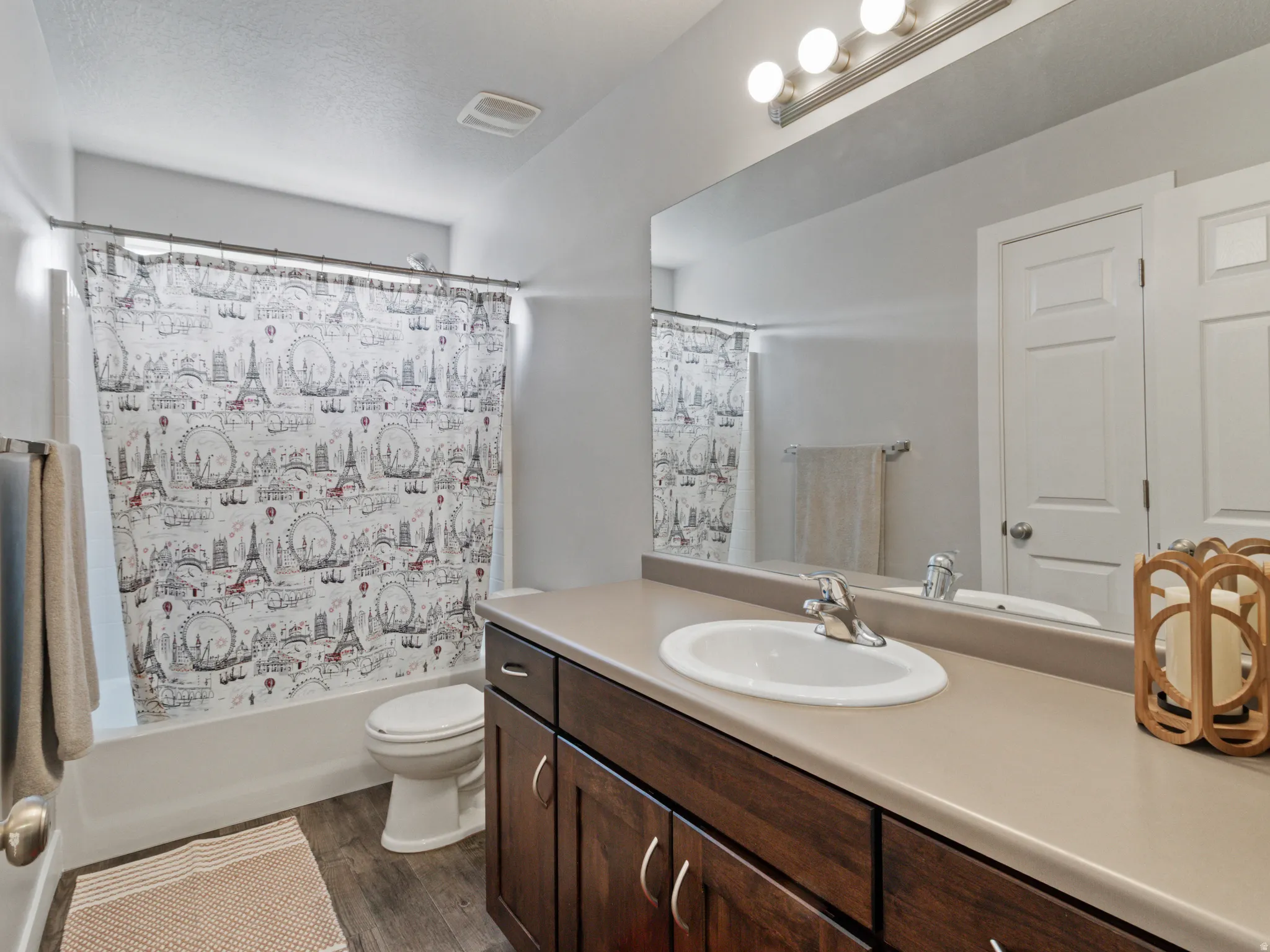 Full bathroom featuring a single vanity with dark wood cabinetry, a light-toned countertop, and an integrated sink