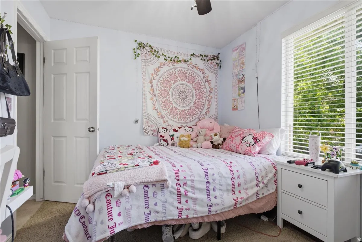 Bedroom featuring a window with white horizontal blinds