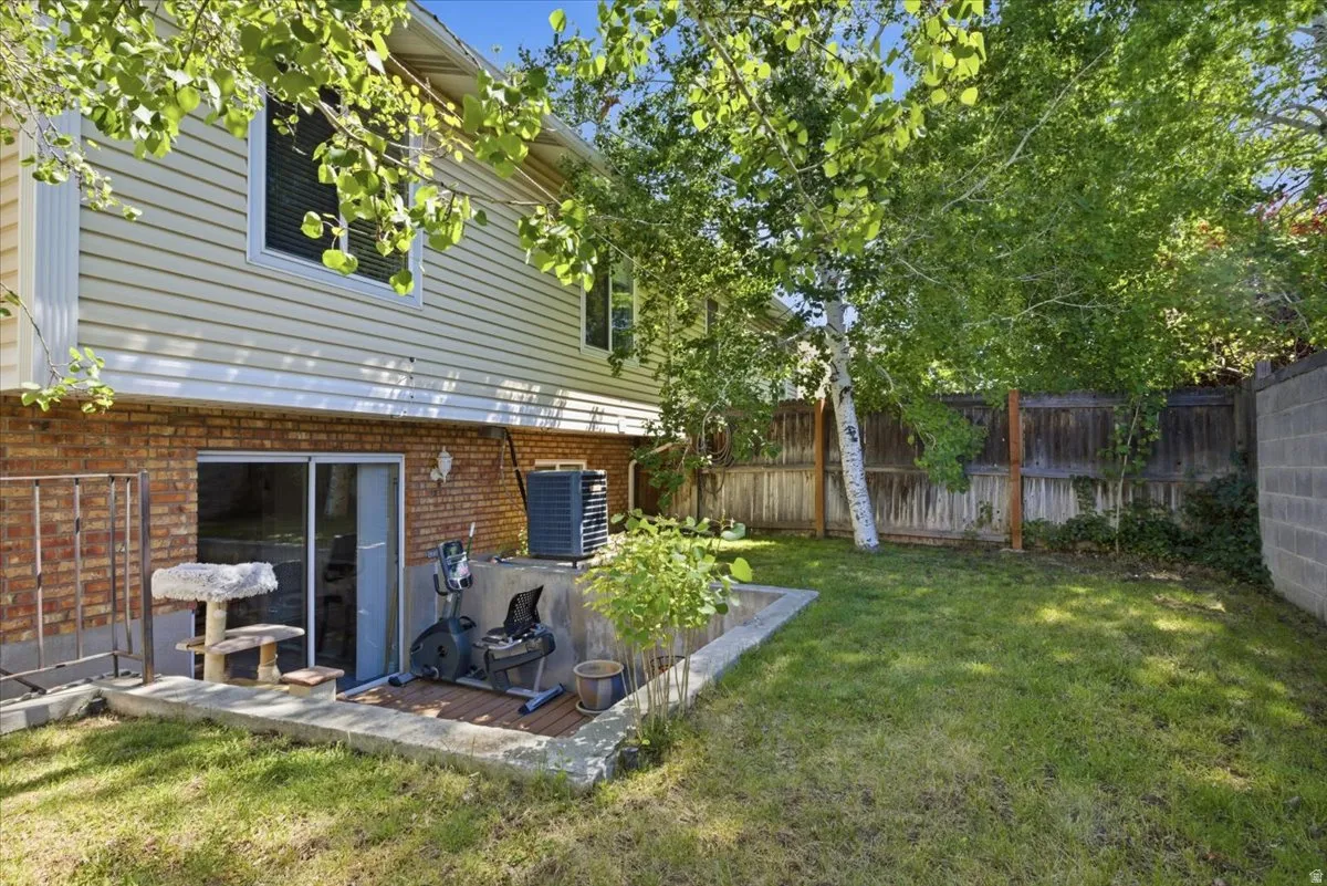 Rear exterior featuring a walk-out basement with sliding glass doors, a brick foundation, and horizontal siding