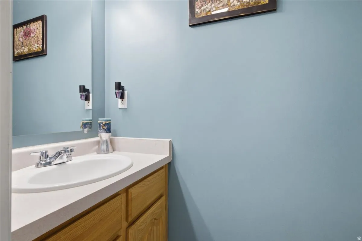 Vanity featuring a white oval sink, chrome faucet, and light-colored countertop