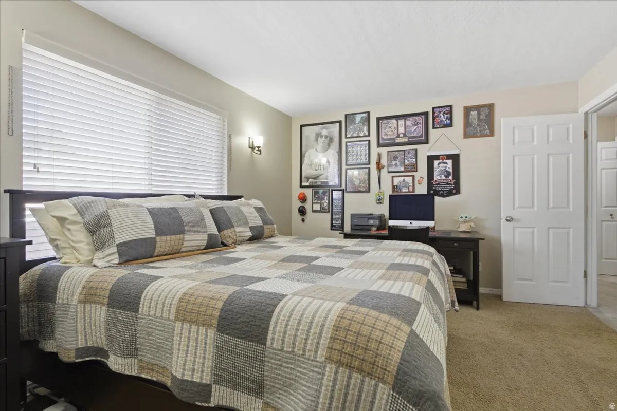 Bedroom featuring light beige wall paint, white horizontal blinds, and a white six-panel door