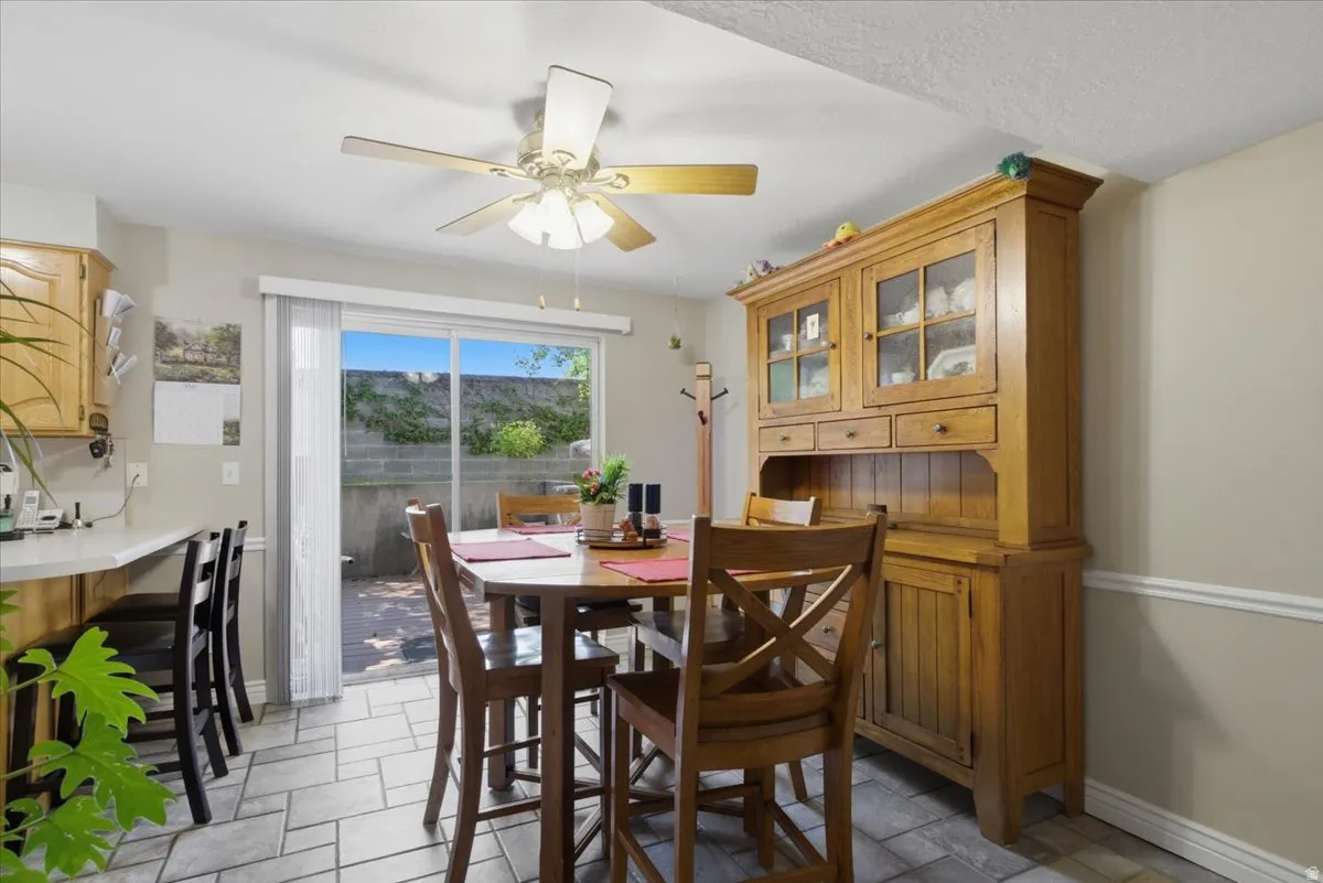 Dining area featuring tile flooring, a ceiling fan, and sliding glass doors to the exterior