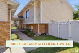 Brick and vinyl-sided residence with attached garage featuring brick detailing