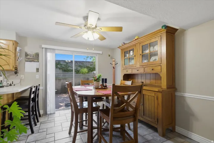 Dining area featuring tile flooring, a ceiling fan, and sliding glass doors to the exterior