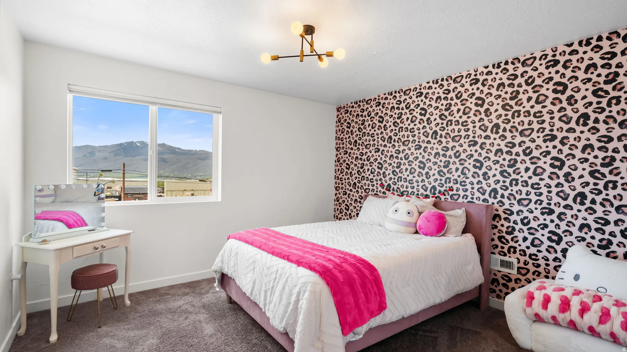 Interior room featuring a statement wall with a leopard print pattern, white walls, and gray carpet flooring