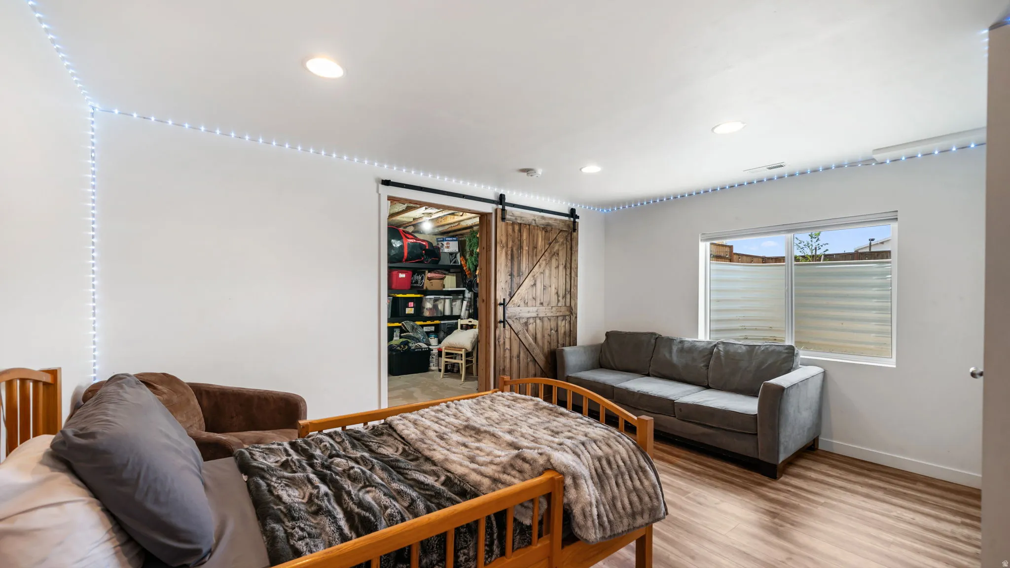 Spacious room featuring wood-finish flooring, recessed lighting, and a window with a frosted privacy screen