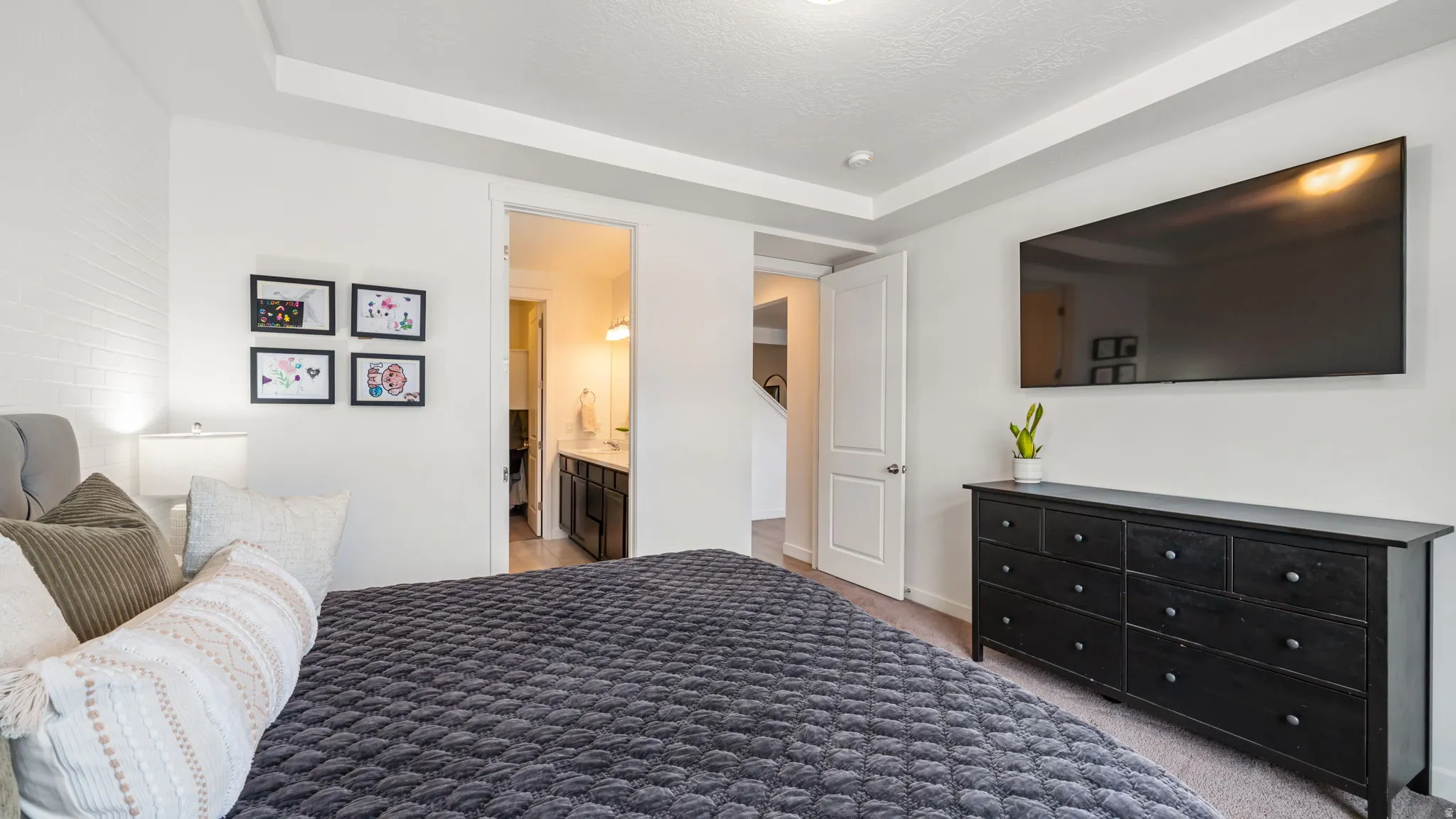 Master bedroom. Tray ceiling bedroom with light gray carpeting and white walls