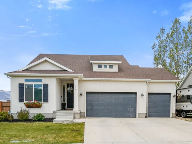 Contemporary stucco exterior with dark shutters and a decorative window box