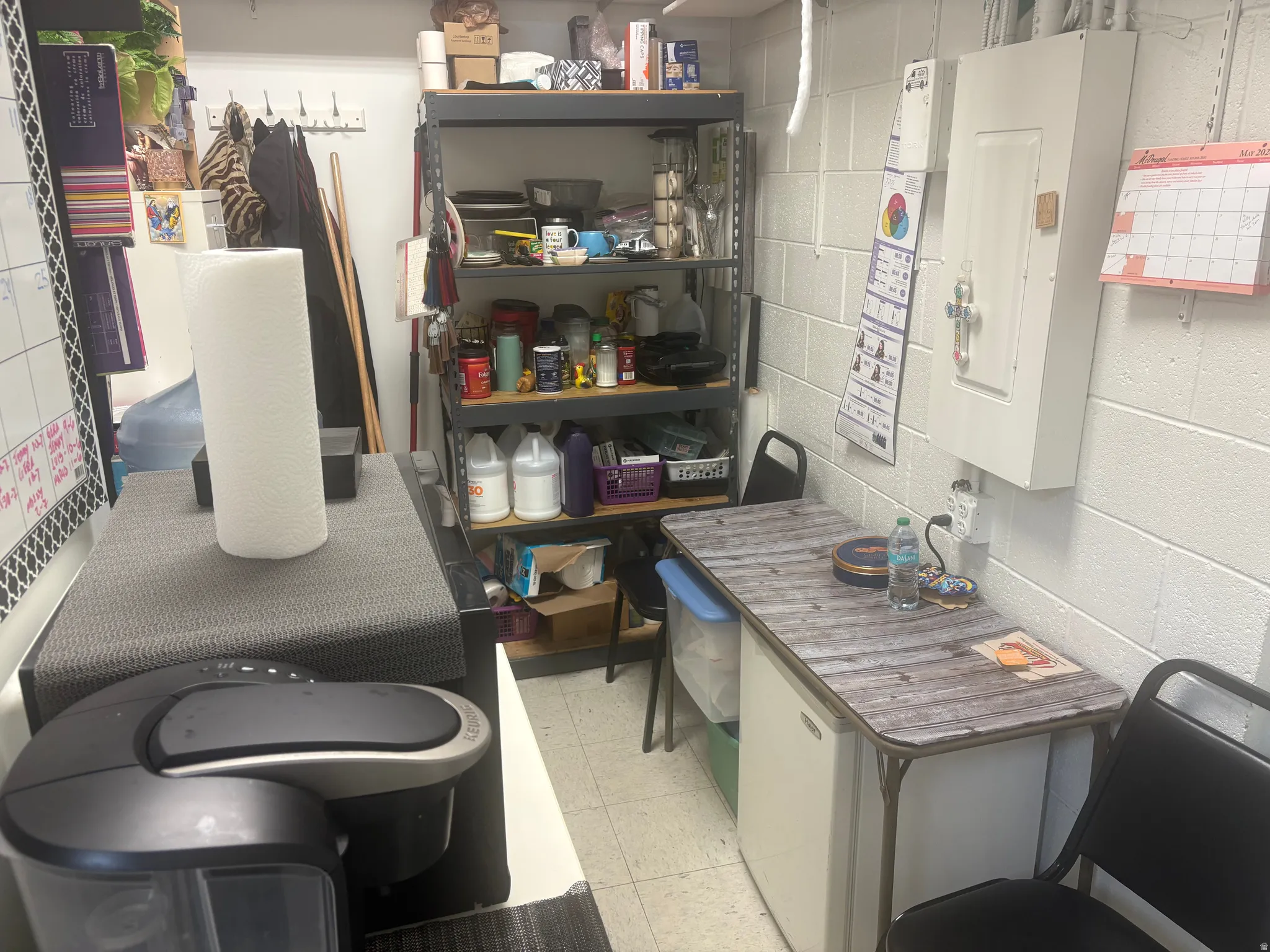 Utility space featuring white painted block walls and a metal shelving unit