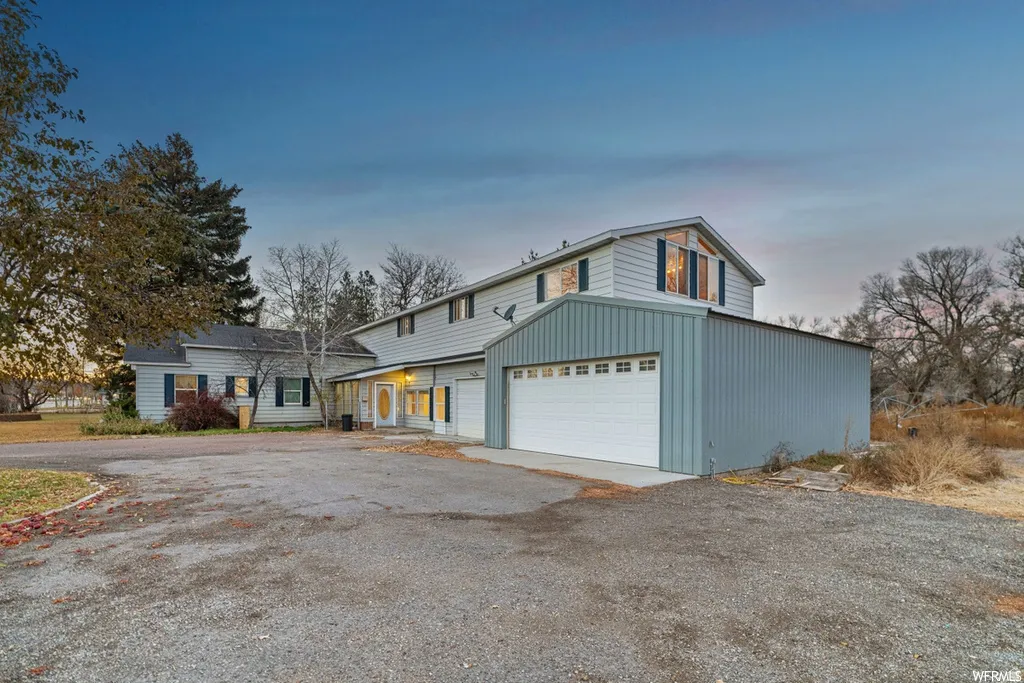 View of front of property with driveway and an attached garage