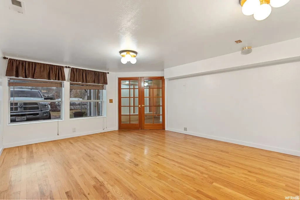 Spare room featuring french doors and light wood-style floors