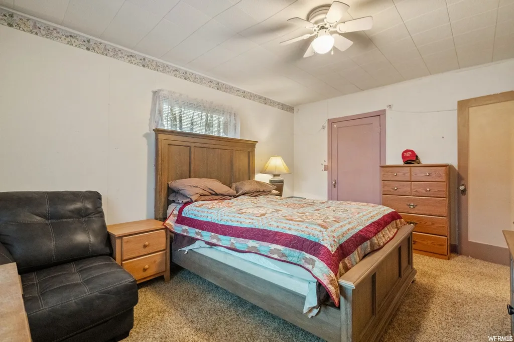 Bedroom with light carpet and a ceiling fan