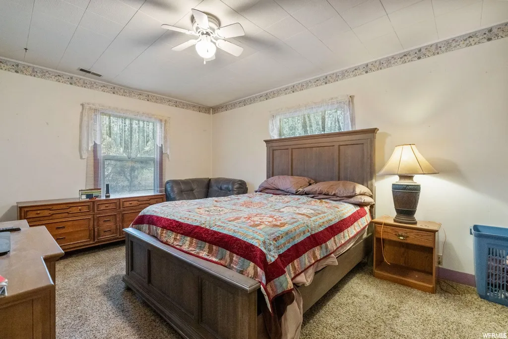 Bedroom featuring light colored carpet and a ceiling fan