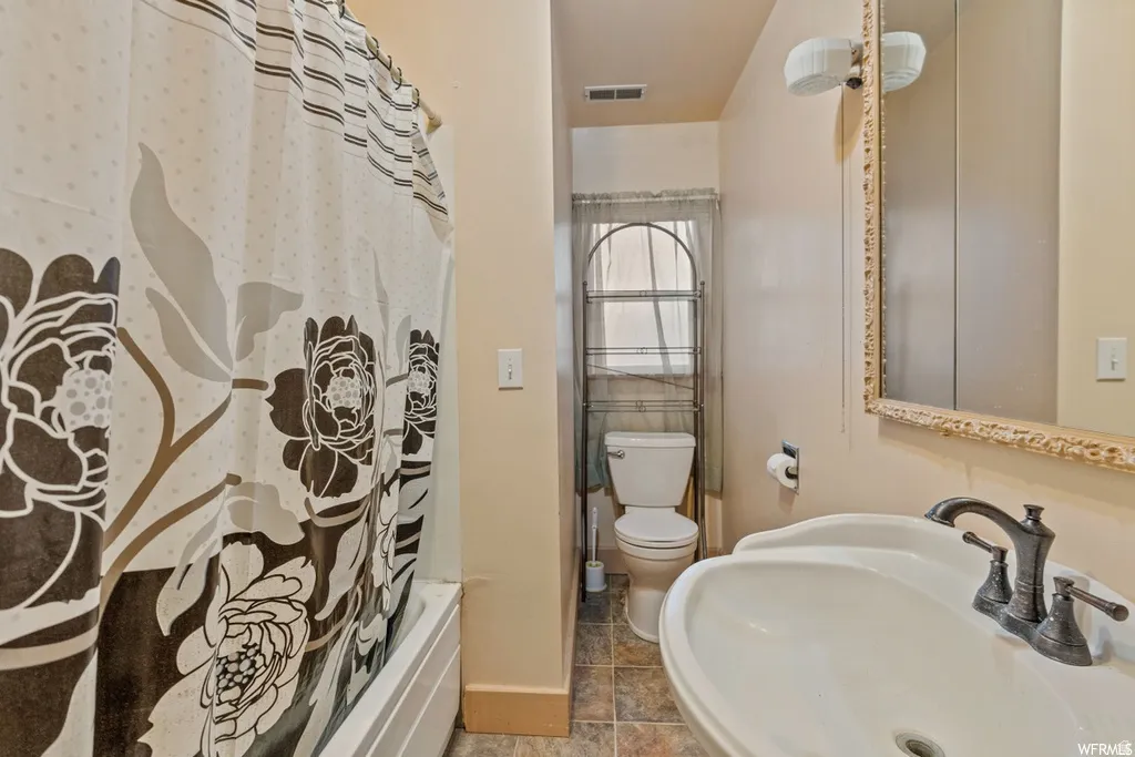 Bathroom featuring a sink and shower / bath combination with curtain