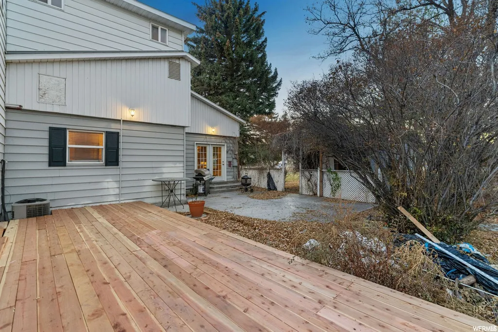 Deck at dusk with a patio area, area for grilling, and french doors