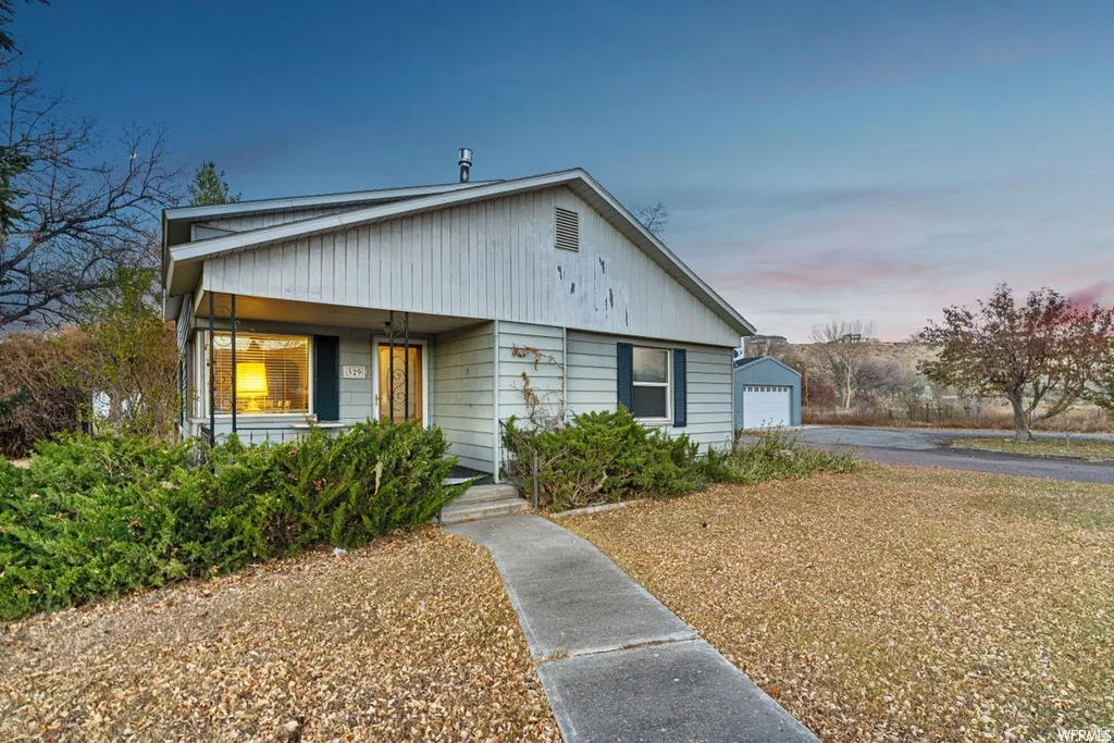 Bungalow-style house featuring an outdoor structure, a detached garage, and covered porch
