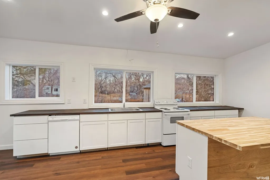 Kitchen with butcher block countertops, white appliances, white cabinets, recessed lighting, and dark wood-style flooring