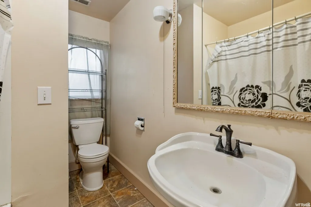 Bathroom featuring a sink and a shower with shower curtain