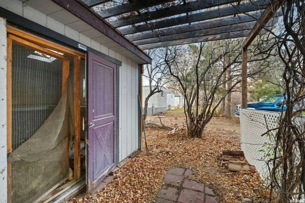 View of exterior entry with a pergola